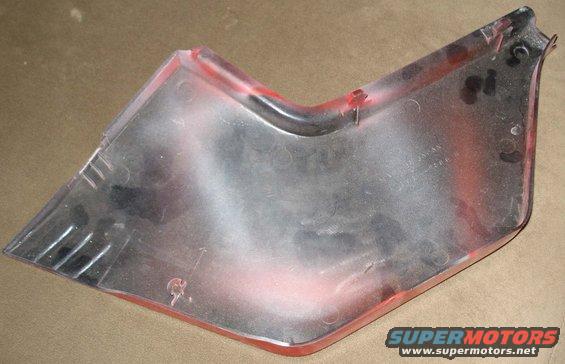 Red and clear plastic automotive trim piece with scuff marks and visible "SUPERMOTORS www.supermotors.net" text