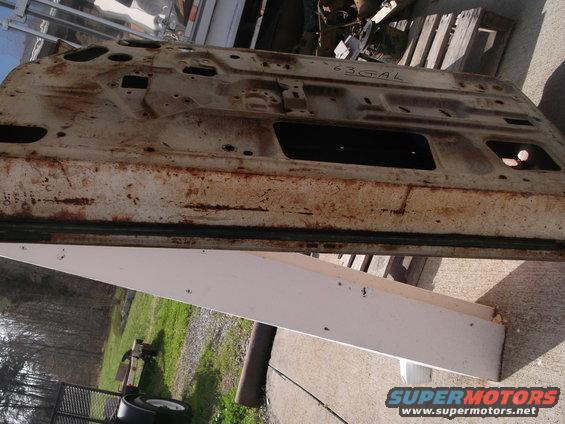 Rusty car door with "63 GAL" stamped on it
