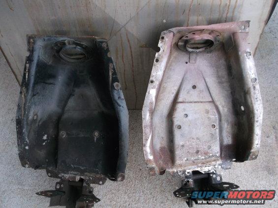 Two old car fuel tanks, one black and one rusty, side by side