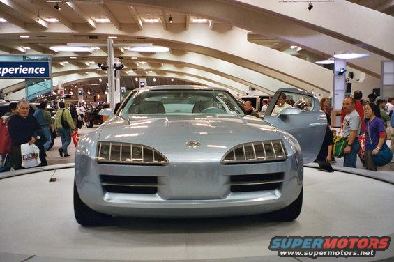Silver concept car with gull-wing doors open, front view