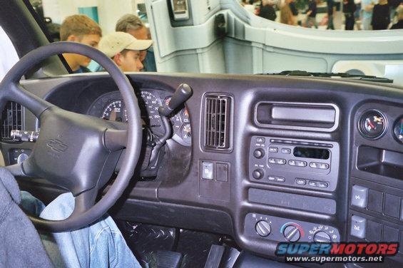 Dashboard and steering wheel of a van, with people looking in from the side