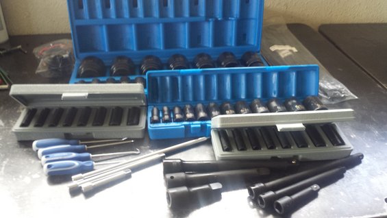 Socket set and screwdrivers on a metal surface