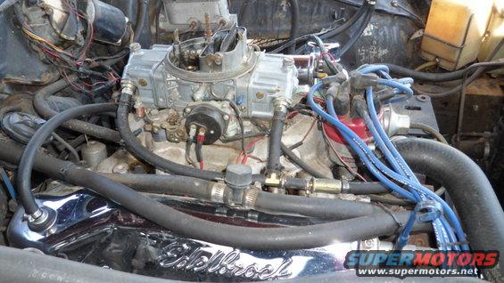 Close-up of a V8 engine with a Holley carburetor and blue spark plug wires