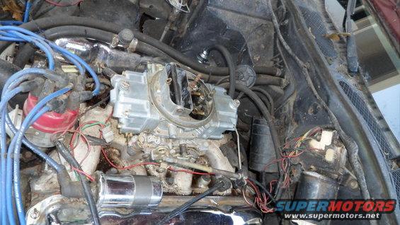 Engine bay with carburetor, distributor, and blue spark plug wires