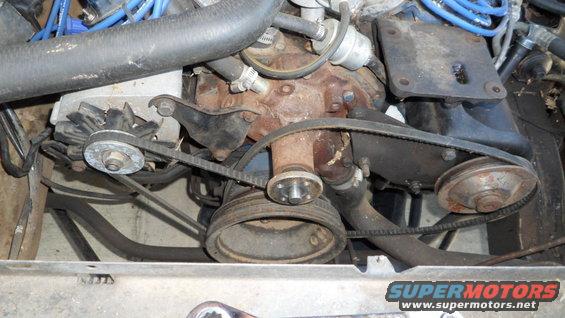 Engine bay with rusty water pump, alternator, and belts