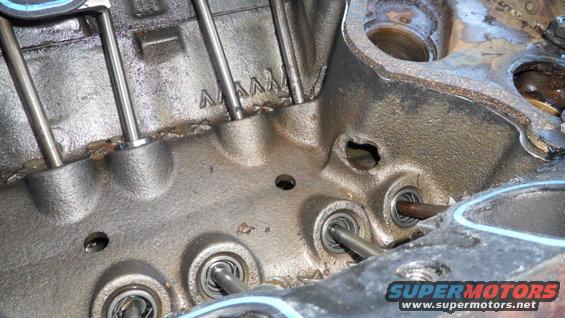 Engine block interior with pushrods and valves visible. Text 'AMAM' stamped on block