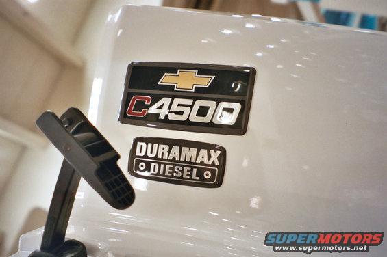 Close-up of a white truck fender with Chevrolet and C4500 badges, plus a Duramax Diesel emblem