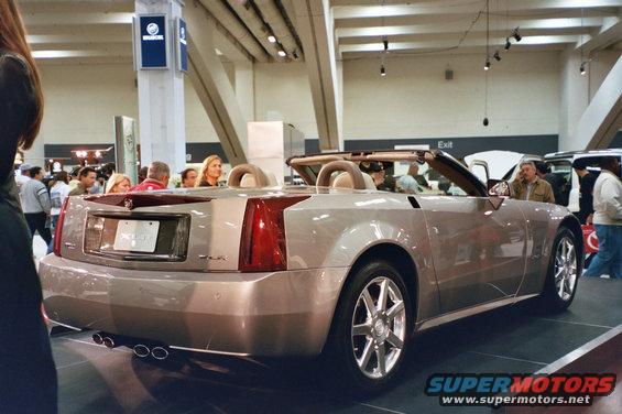 Silver convertible with tan interior on display at an auto show
