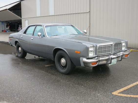 Gray 1970s Dodge Monaco parked outside a building