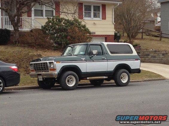 Green and white Ford Bronco parked on street, front quarter view