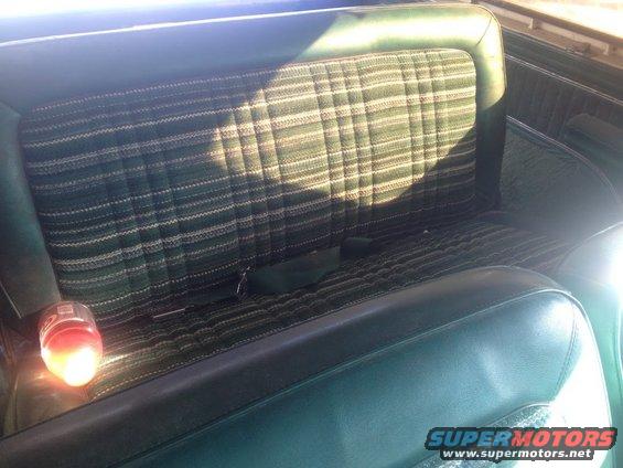 Back seat with green plaid upholstery and a seatbelt
