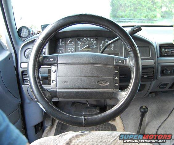 1994 Ford Bronco interior dashboard with Ford logo on steering wheel and aftermarket gauge