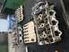 1996 Ford Probe - Disassembled engine cylinder heads are laid out on a workbench next to a NAPA Power parts box.