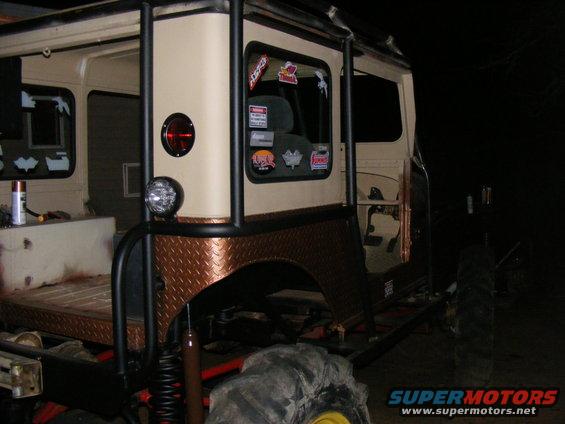 Off-road vehicle with roll cage, diamond plate fender flares, and stickers on window