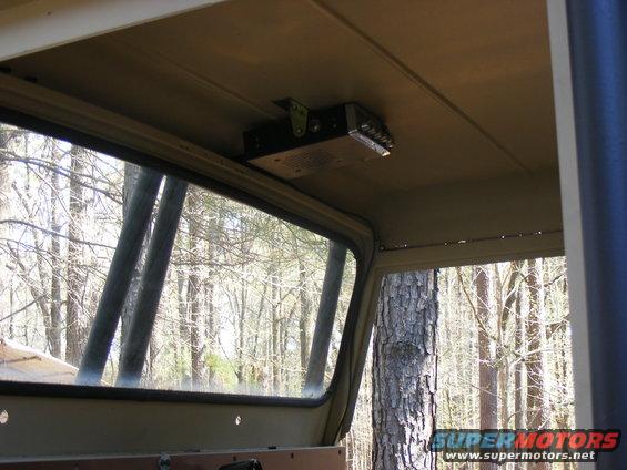 Interior view of a vehicle showing a CB radio mounted on the headliner above the side window