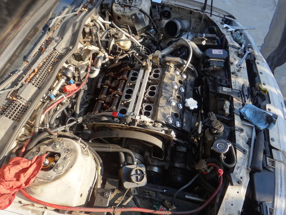 Engine bay of a 1993 Ford Taurus with the valve covers removed, showing the camshafts and intake manifold