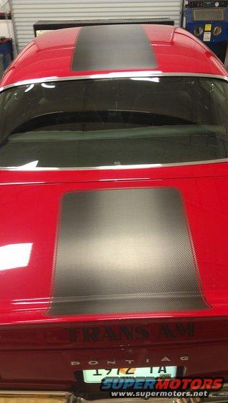 Rear view of a red 1972 Pontiac Trans Am with black racing stripes on the hood and roof