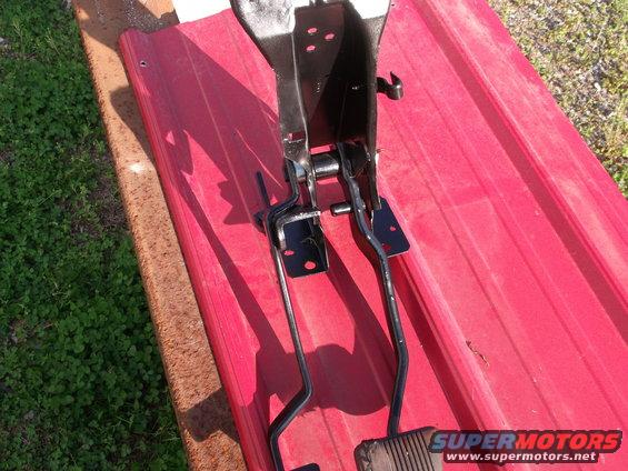 Brake and clutch pedals assembly on red surface