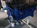 1967 Ford Mustang - A blue engine block with visible valve springs and a fuel pump is mounted on an engine stand.