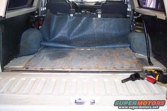 1990 Ford Bronco interior cargo area with blue mat and metal floor