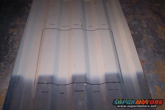 Metal panel with cut lines drawn on it, possibly for a floor access panel