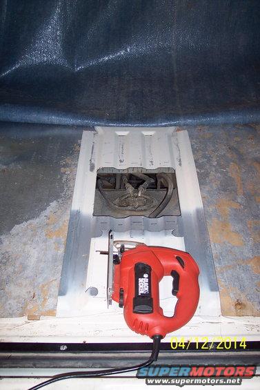 Red jigsaw next to open fuel tank access panel