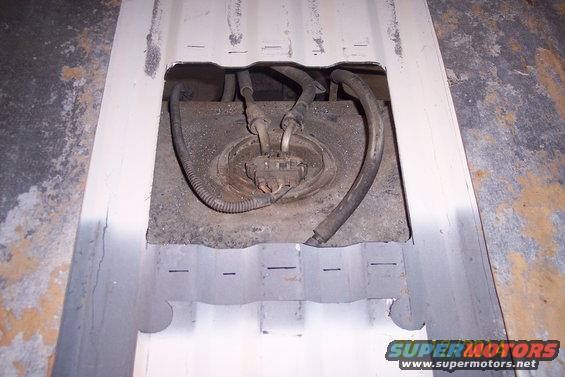 Fuel tank access panel with fuel lines and electrical connector visible