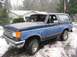 1988 Ford Bronco - This Ford Bronco is parked outside a house in a snowy environment. The vehicle has a two-tone paint scheme.