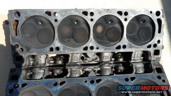 Engine cylinder heads with valves visible, some carbon buildup