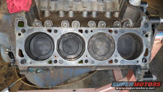 Engine block showing four cylinders with pistons visible