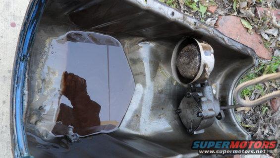 Oil pan with dark oil and a small oil pump assembly attached