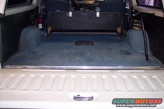 1990 Ford Bronco interior cargo area with blue carpet and folded rear seat