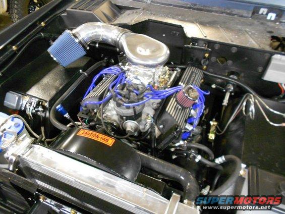 Engine bay with V8 engine, blue spark plug wires, and aftermarket air intake