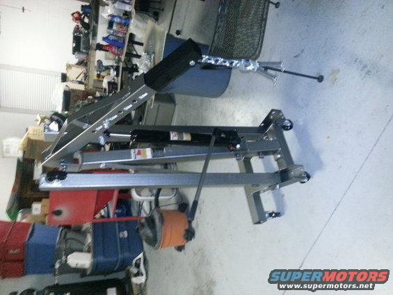 Engine hoist in a cluttered garage with shelves and boxes