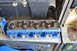 1981 Ford F-250 - A blue painted engine cylinder head with valve springs is shown, resting on a shelf.