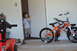 1981 Ford F-250 - A young boy stands in a doorway next to an orange bicycle equipped with training wheels.