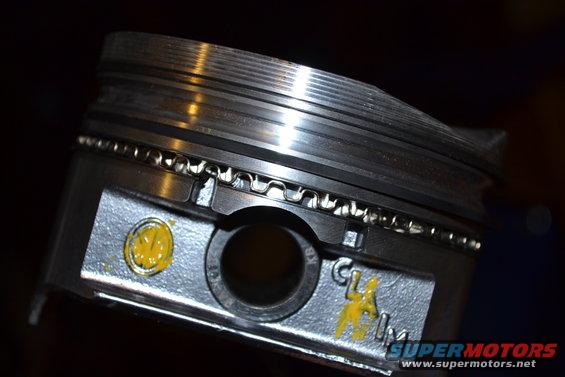 Piston with three rings, yellow markings, and "CL" stamped on it