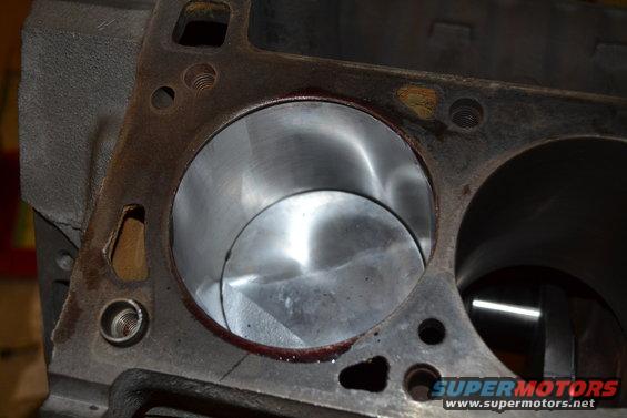 Engine block cylinder bores with visible honing marks and some rust residue