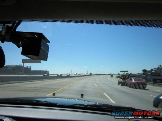 Interior view of a highway scene with a tow truck and pink car