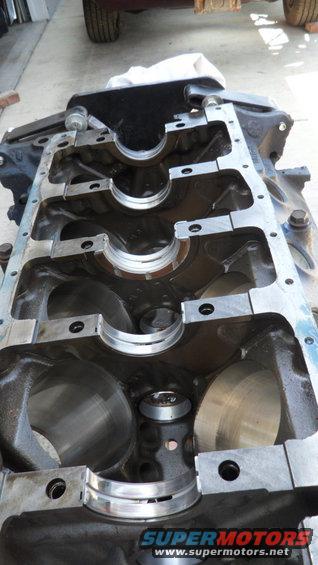 engine block with main bearing caps removed, showing cylinder bores and crankshaft bearing saddles