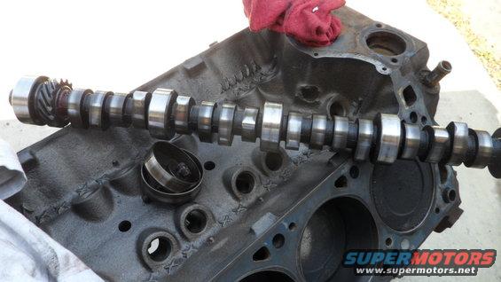Camshaft resting on an engine block, with a red rag on top