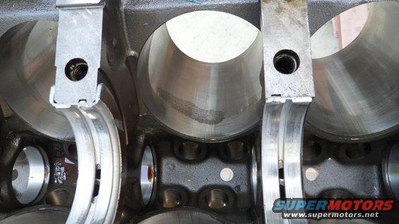 Engine block cylinders with bearing caps installed. Supermotors.net logo visible