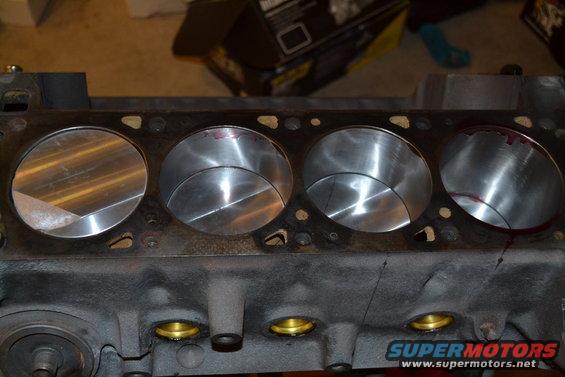 Engine cylinder head with four cylinders visible. Some red marking inside cylinders