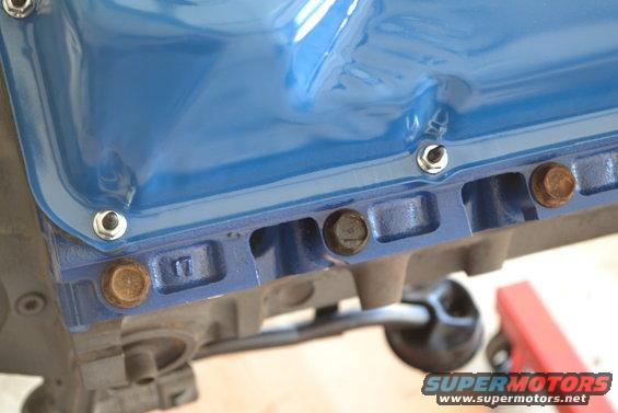 Blue oil pan with bolts on engine block, showing a '17' marking