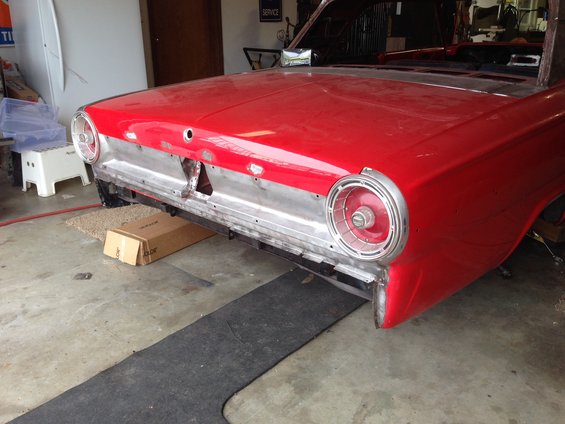 Red 1964 Ford Fairlane rear quarter panel and taillight assembly, undergoing restoration