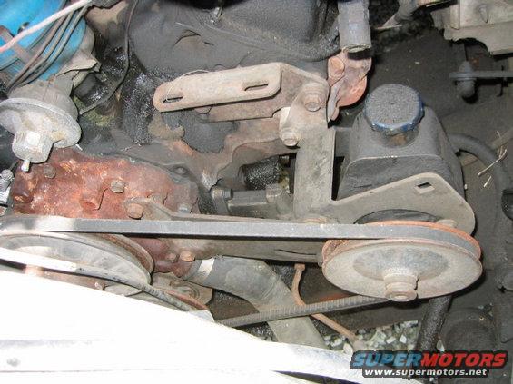 engine bay with power steering pump, belts, and pulleys