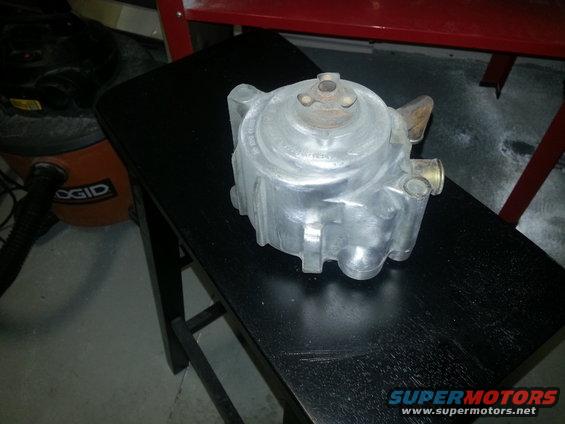 metal automotive part on black stool, shop vac in background