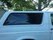 1992 Ford Bronco - The side profile of a white SUV shows its rear window area with dark tinting and a watermark at the bottom.