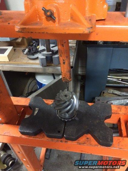 Differential ring and pinion gear set on a press plate. Text on gear reads '1342 12'