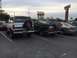 1996 Ford Bronco - Two Ford Broncos are parked side-by-side in a parking lot under an overcast sky.